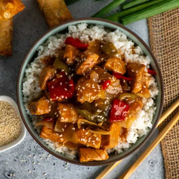 Overhead look at crock pot sweet and sour pork over a bowl of rice.