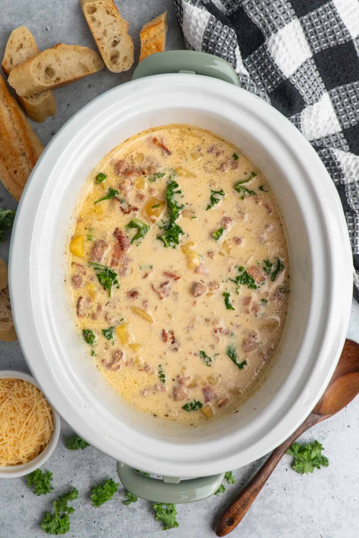 Overhead look a zuppa toscano soup in a crock pot.