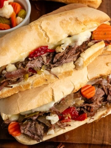 Crock pot Italian beef sandwiches stacked on top of each other.