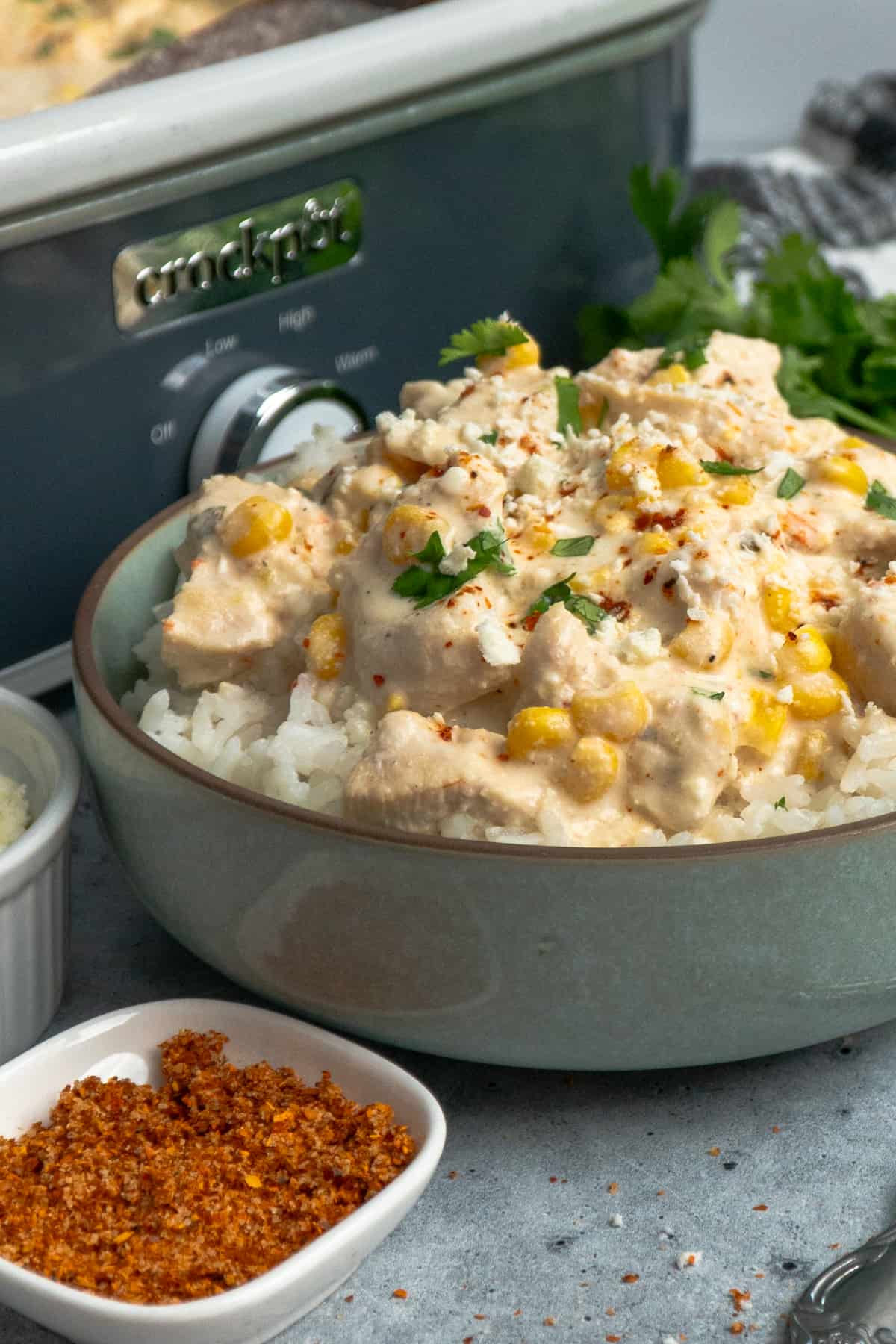 Close-up of crock pot Mexican street corn chicken over a bowl of rice.