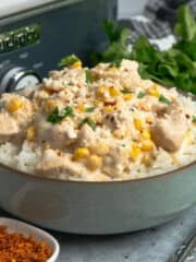 Close-up of crock pot Mexican street corn chicken over a bowl of rice.