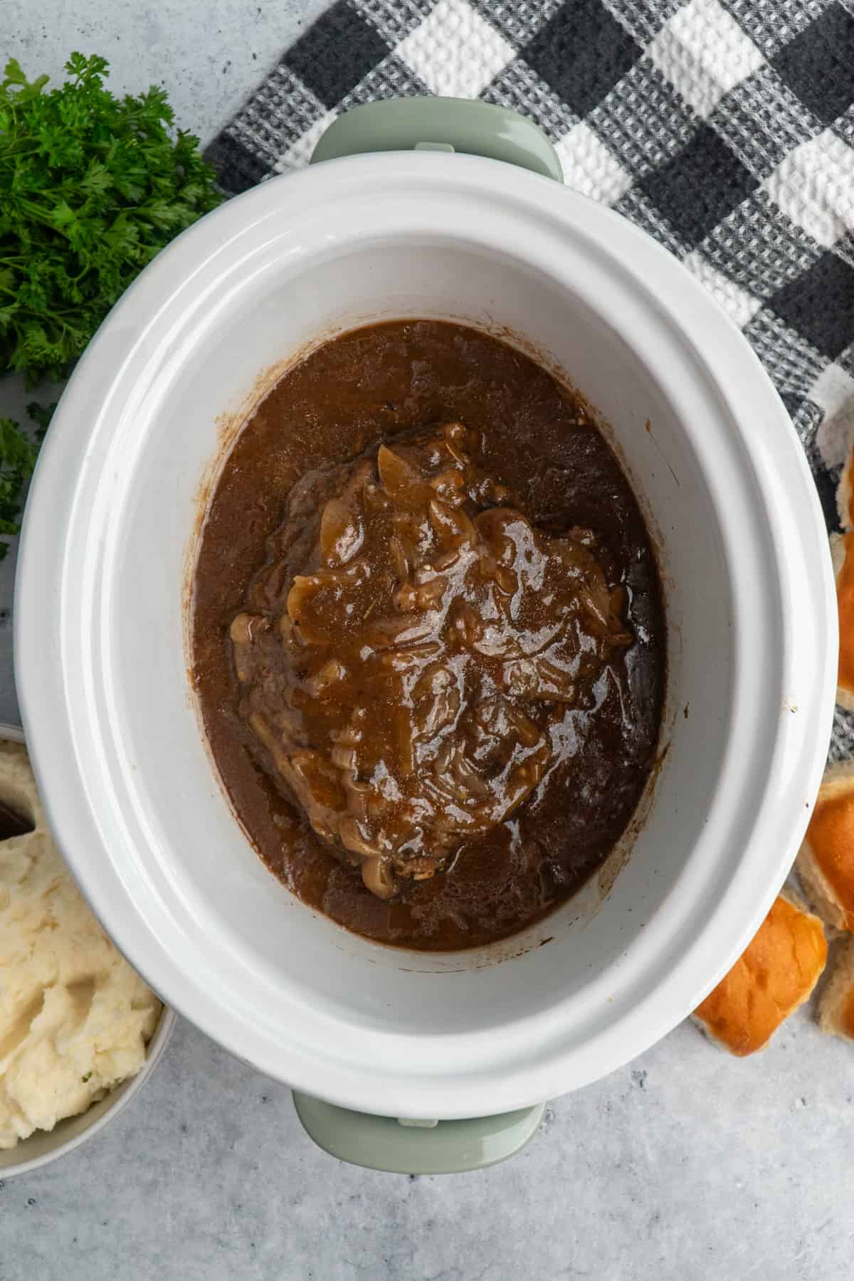 Overhead look at French onion pot roast in a crock pot.