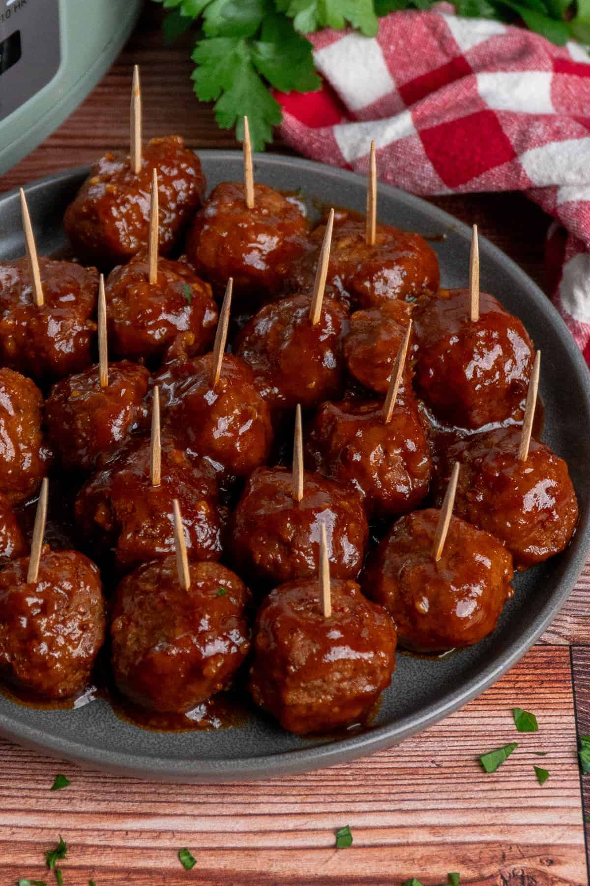 Close-up of BBQ meatballs on a plate with toothpicks in them.