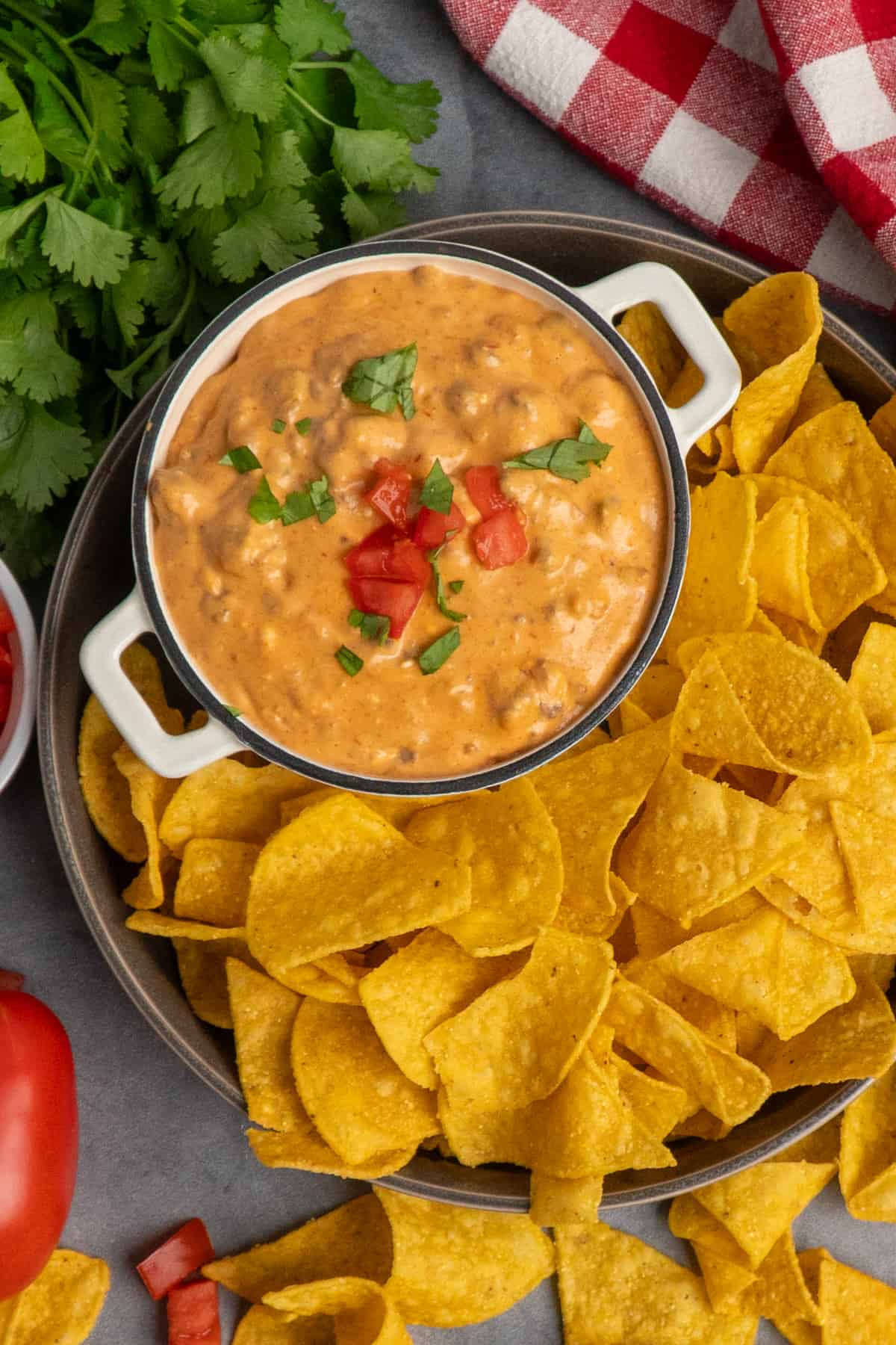 Slow cooker taco dip in a small bowl with tortilla chips.