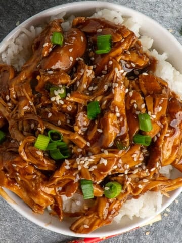 Overhead look at teriyaki chicken rice bowls garnished with green onions.