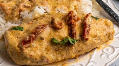 Marry me chicken crock pot served over rice on a white plate.