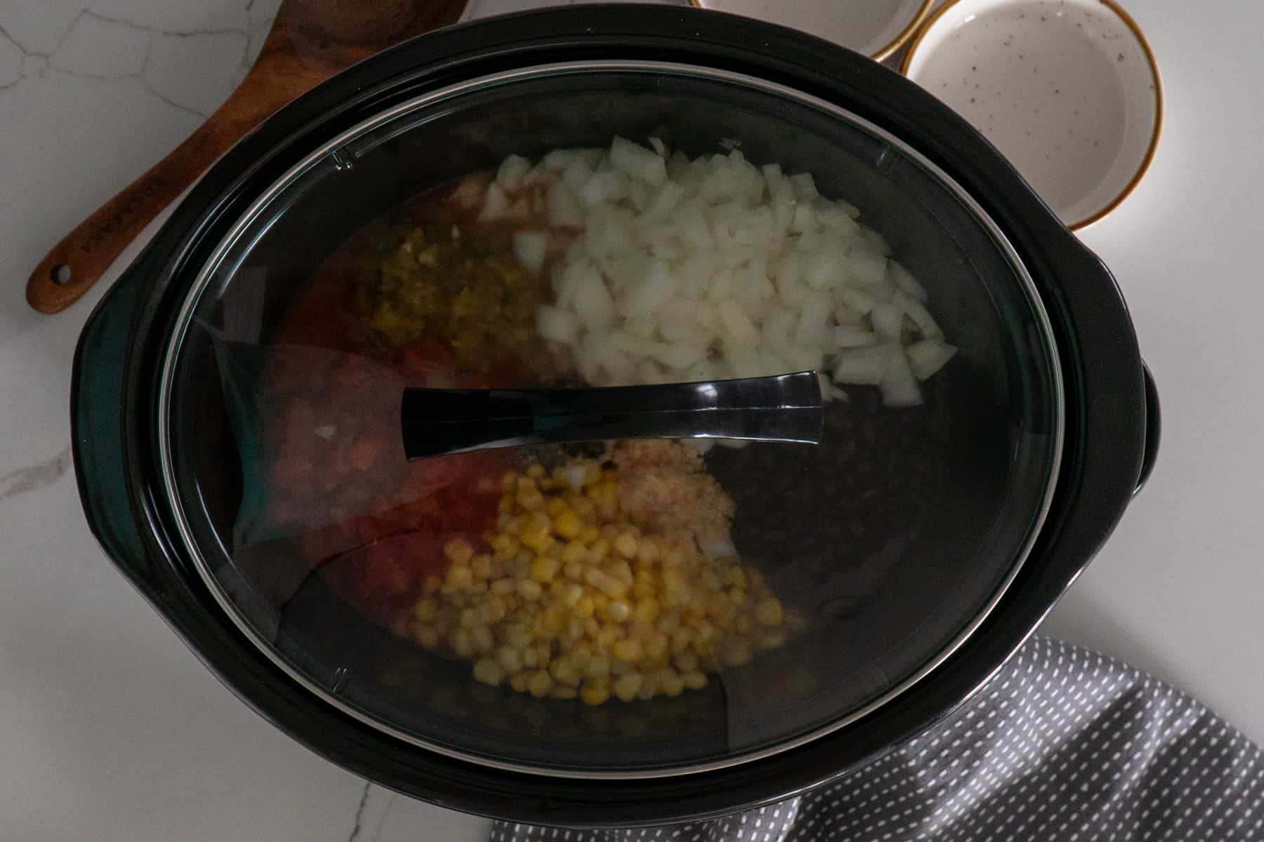 Burrito bowl fill in a slow cooker with the lid on it.
