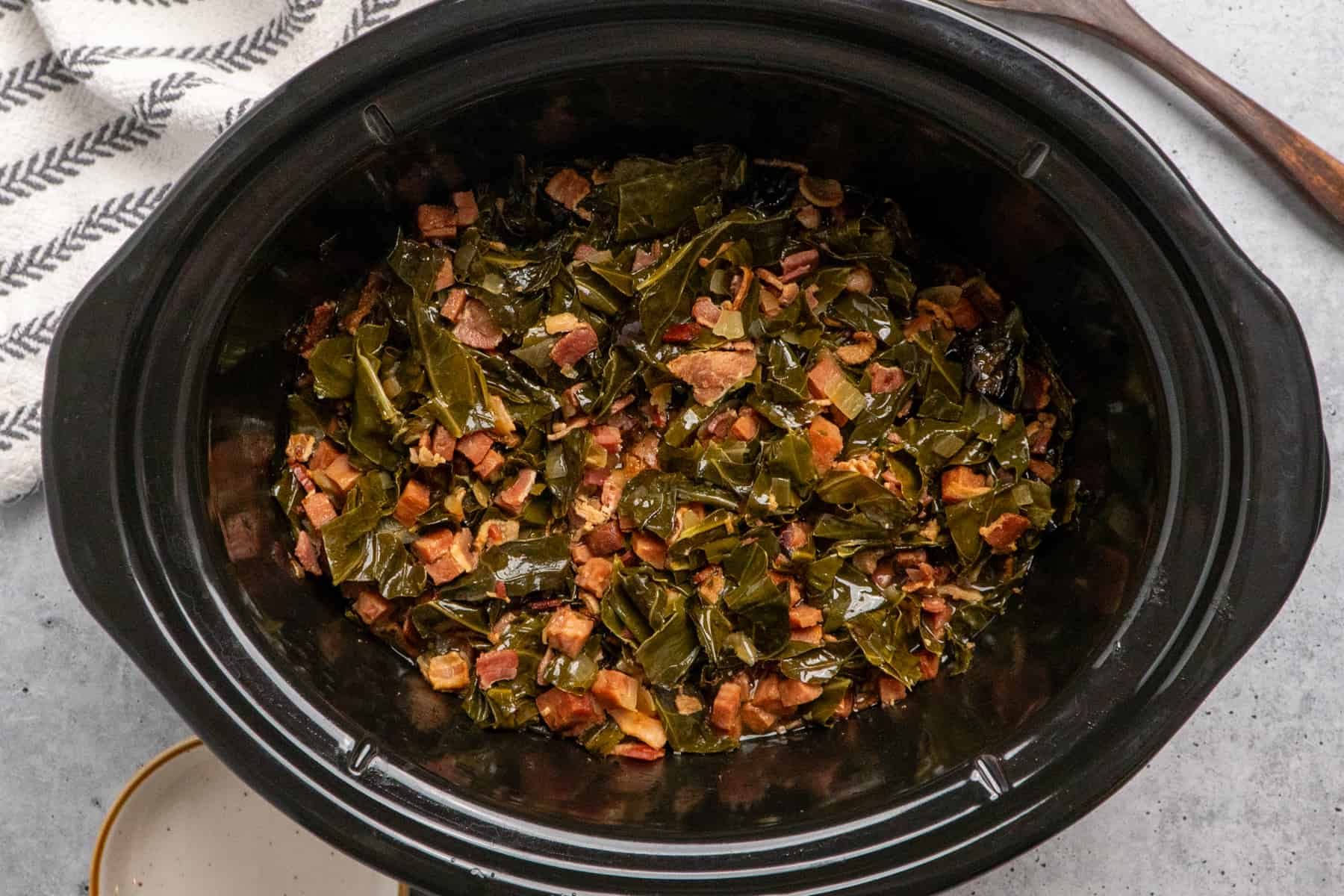 Cooked collard greens in a slow cooker.