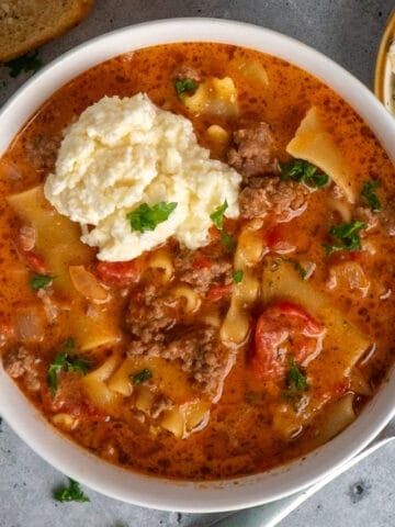 Overhead look at a bowl of crockpot lasagna soup with a cheese topping.