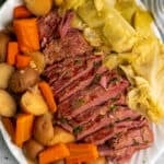 Close up of crock pot corned beef and cabbage on a oval plate.