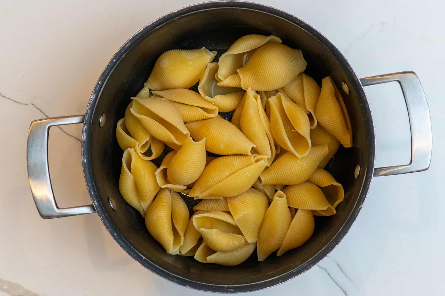 Cooked pasta shells in a pot.