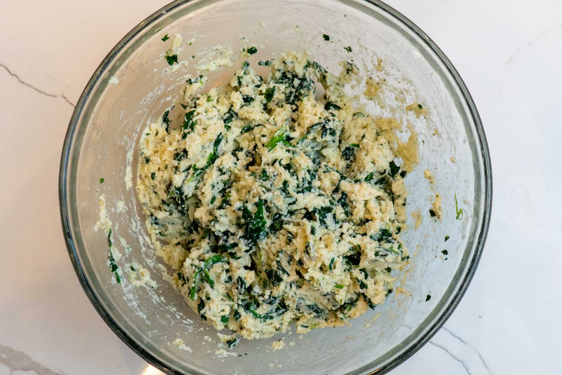Cheese and spinach filling in a bowl.