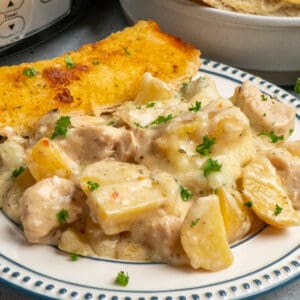 Close up of crock pot garlic parmesan chicken and potatoes on a plate.