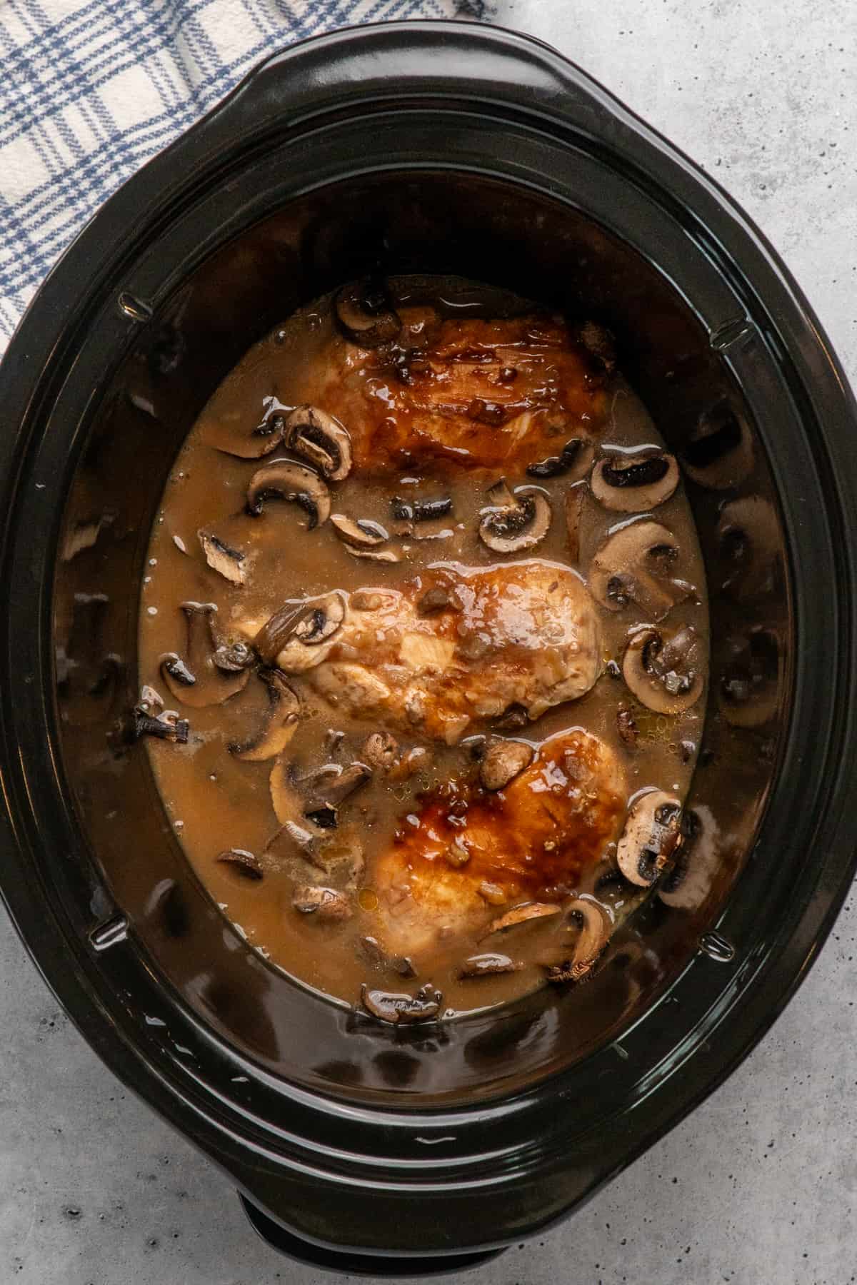 Cook mushrooms and chicken in a slow cooker.