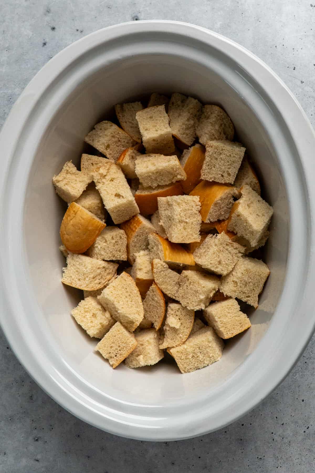One inch pieces of bread in a slow cooker.