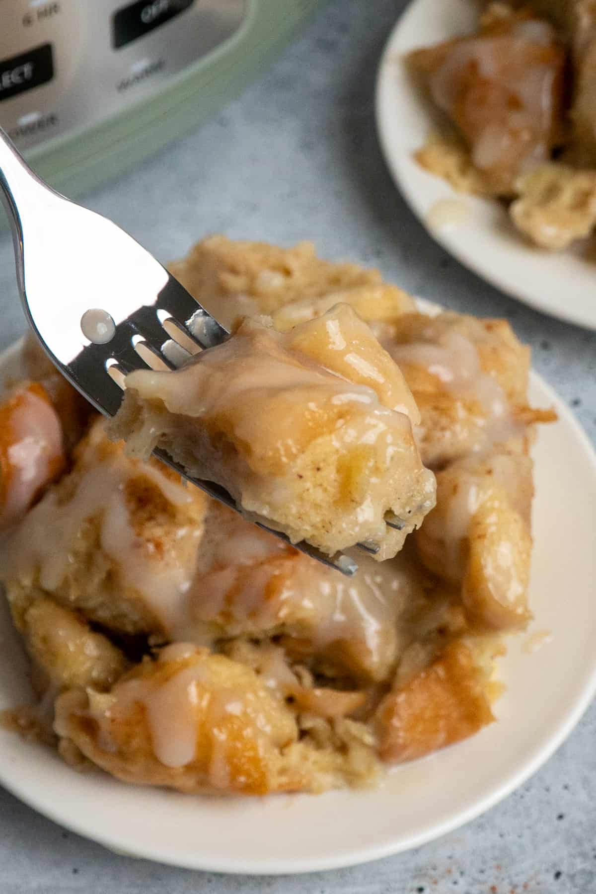 A fork holding a bite of bread pudding.