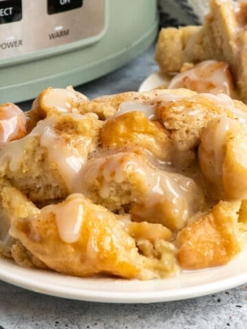 Close up of crock pot bread pudding on a white plate.