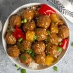 Overhead look at slow cooker teriyaki meatballs over a bowl of rice.