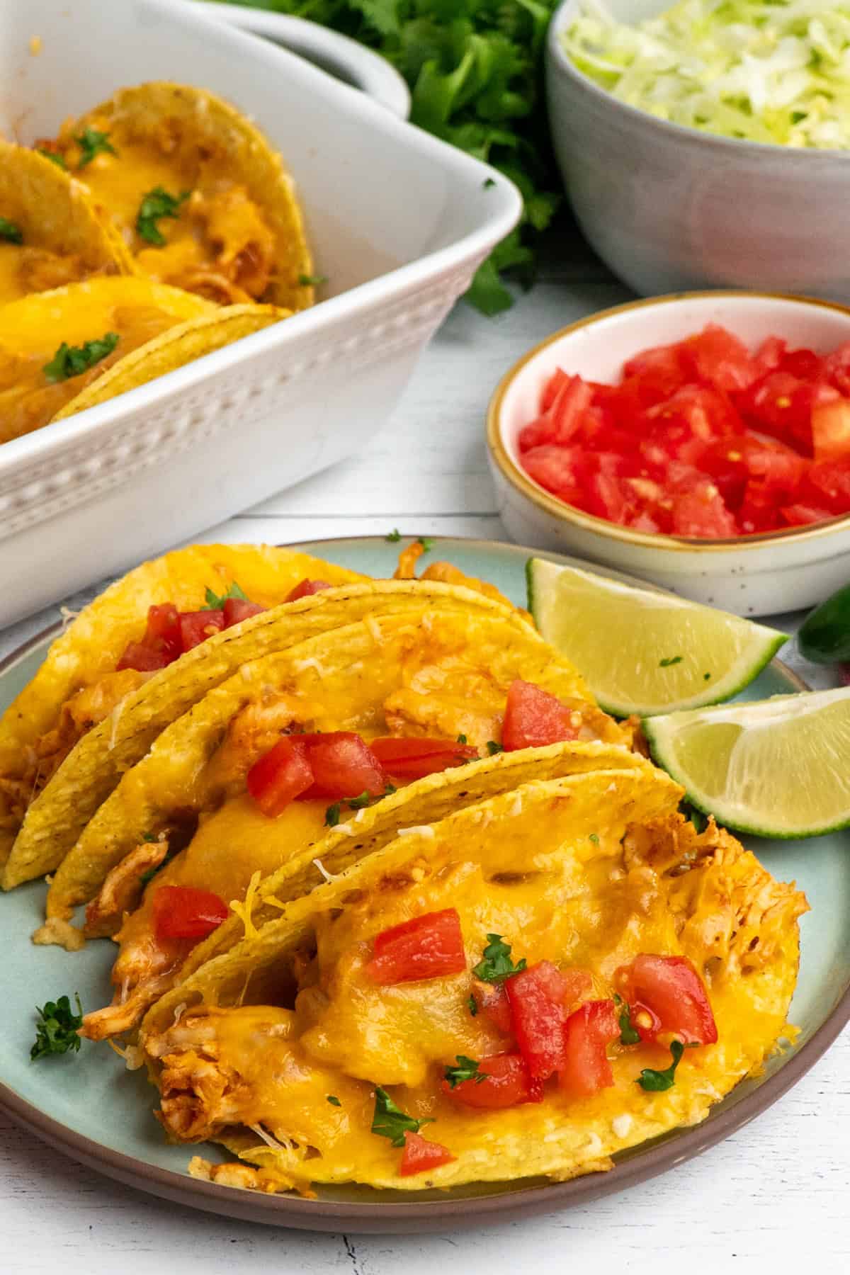 Close up of three chicken tacos on a plate.