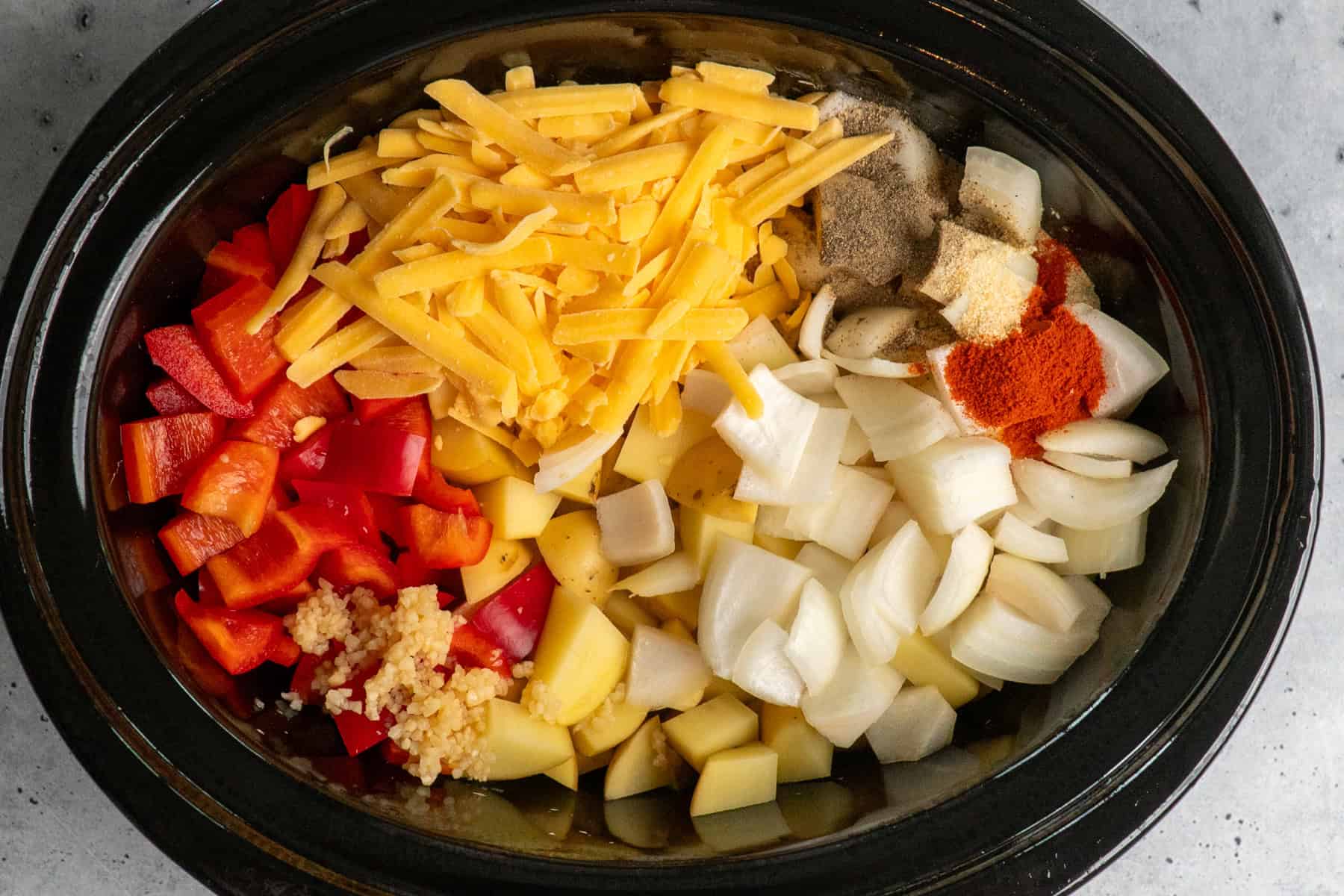 All the ingredients for breakfast potatoes in a Crock Pot.