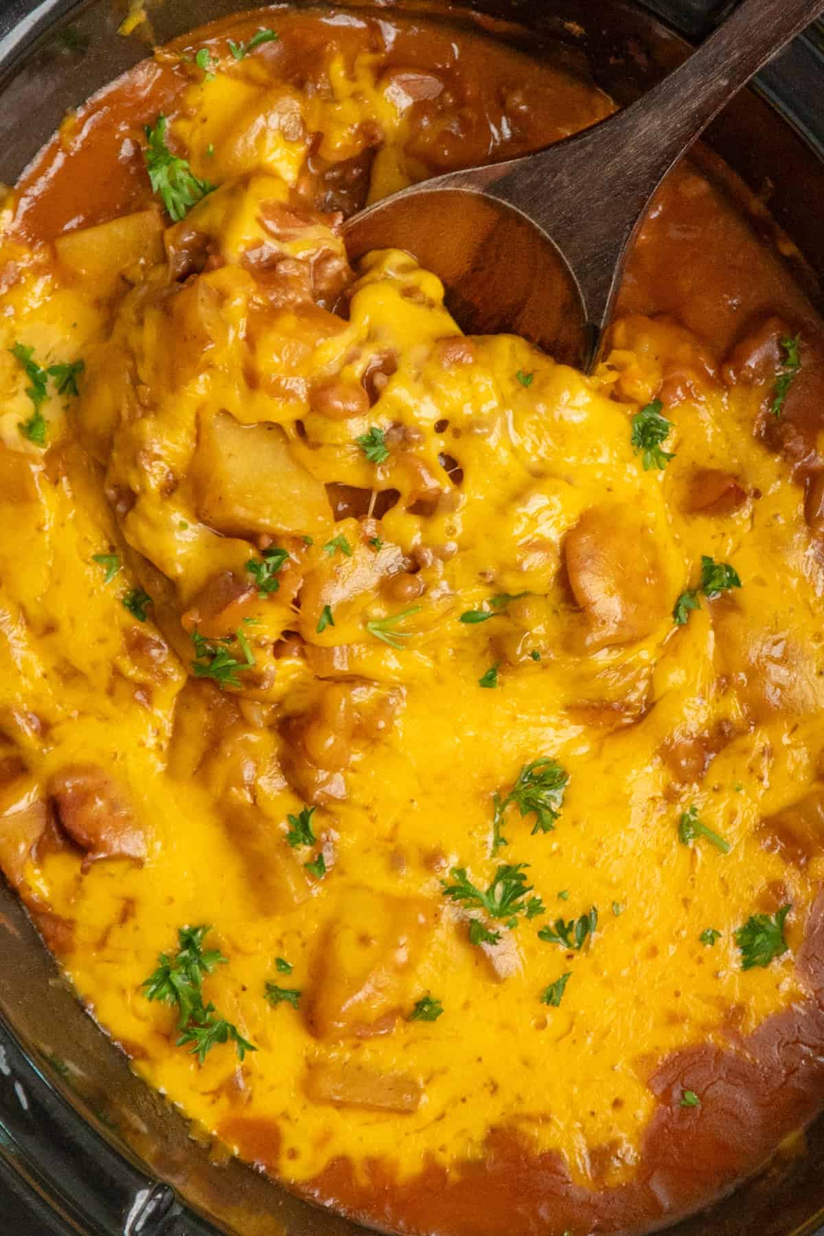 A wooden spoon scooping cowboy casserole.