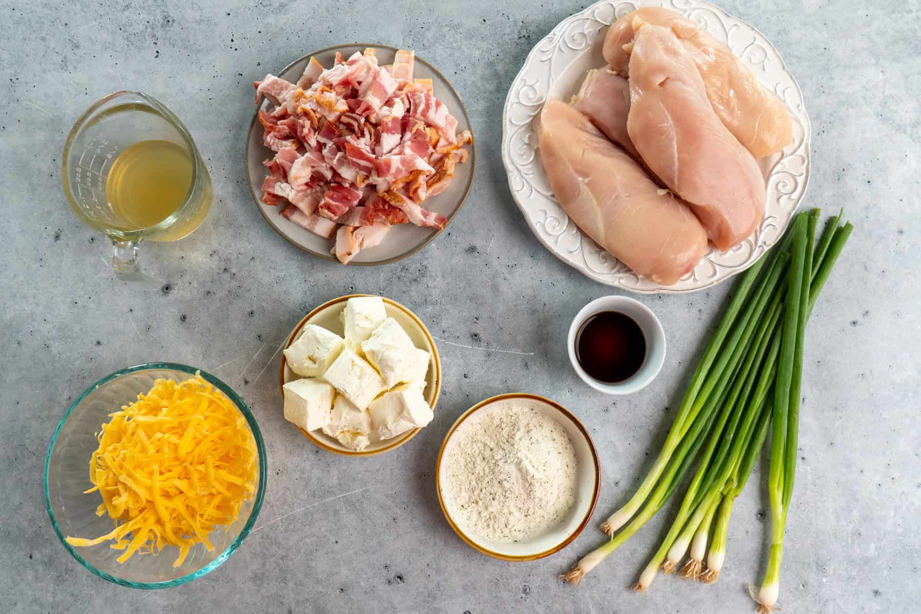 Ingredients for crack chicken arranged on a gray background.