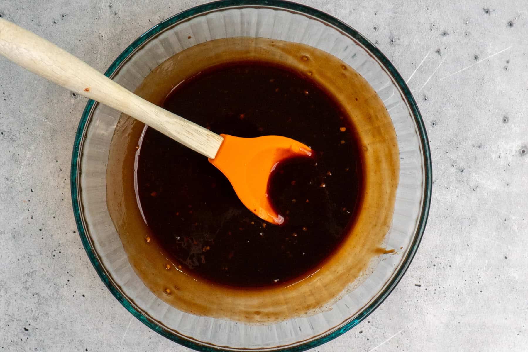 Hawaiian sauce in a clear bowl with a large spoon in it.