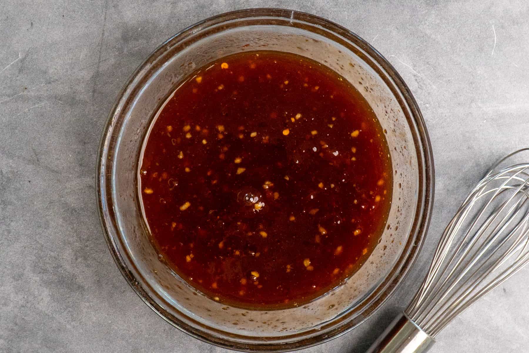 Apricot sauce whisked together in a clear bowl.