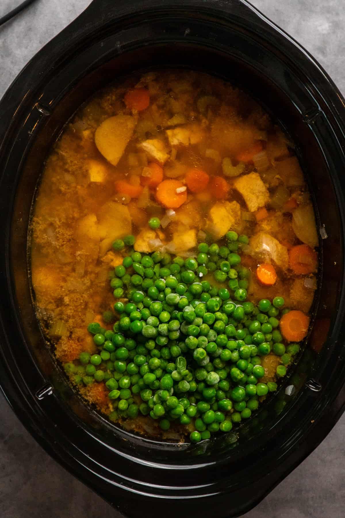 Peas added to slow cooker chicken stew.