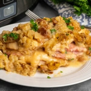 Slow cooker chicken cordon bleu on a white plate and garnished with parsley.