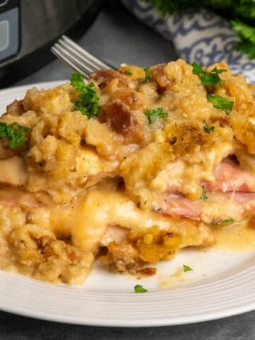 Slow cooker chicken cordon bleu on a white plate and garnished with parsley.