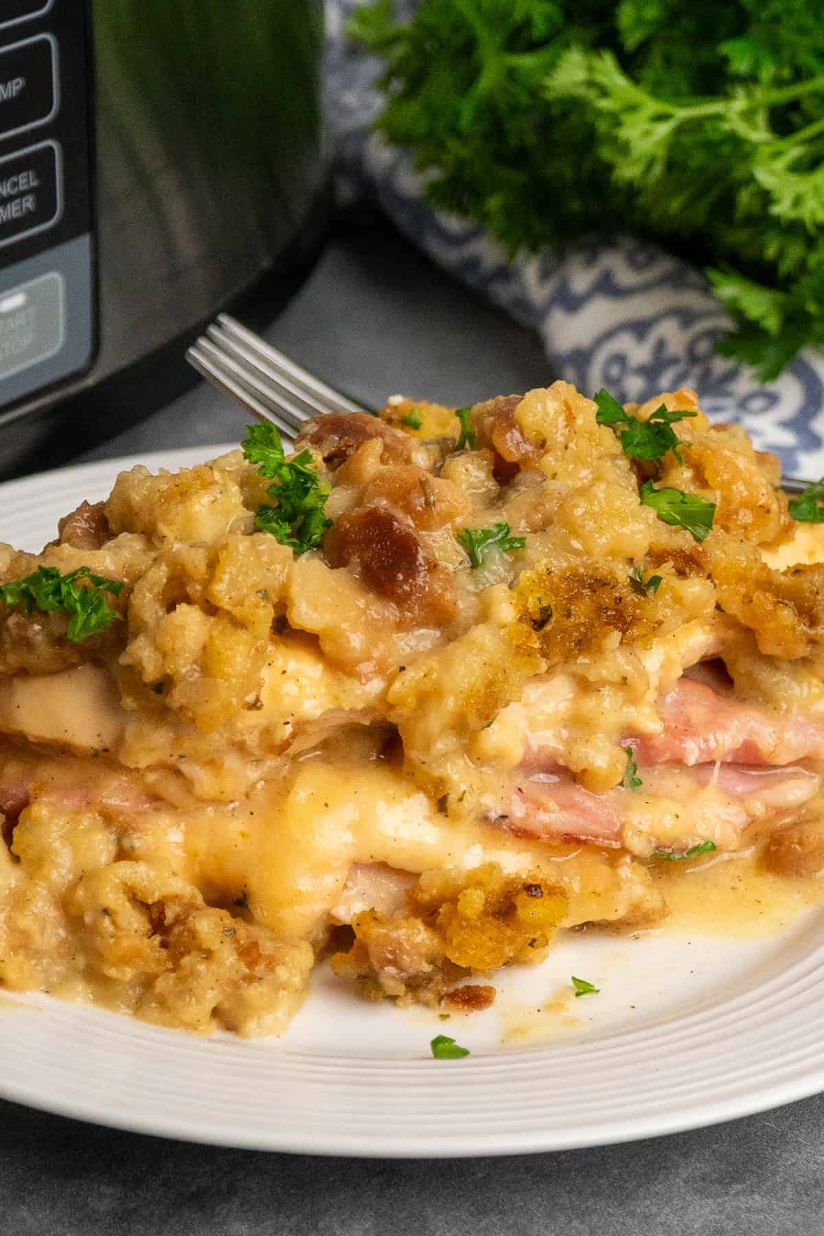 Slow cooker chicken cordon bleu on a white plate and garnished with parsley.