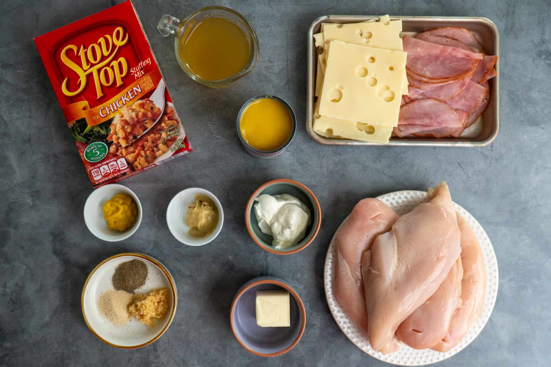 Ingredients to make chicken cordon bleu on a gray counter top.