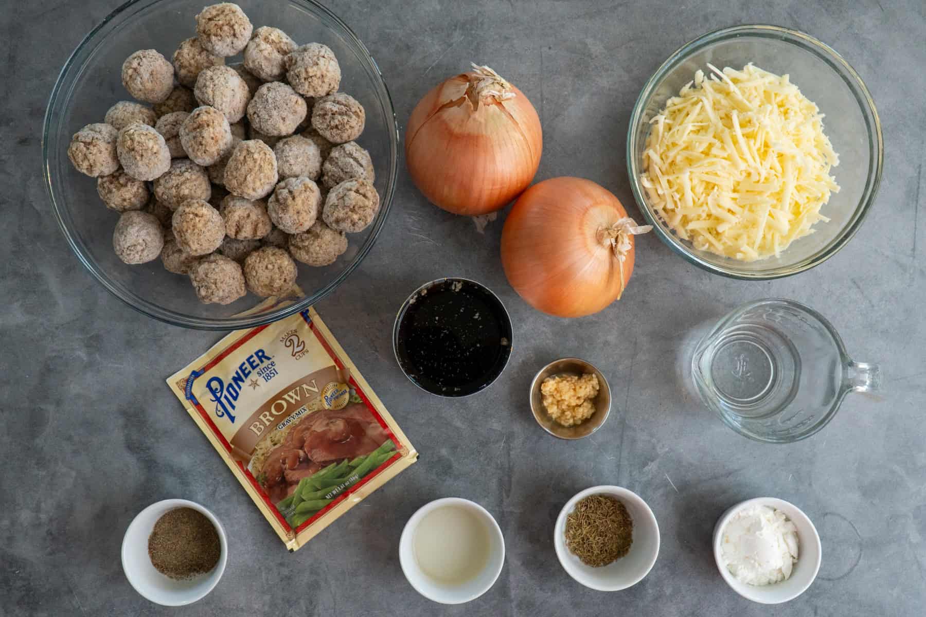 Ingredients for French onion meatballs on a gray countertop.