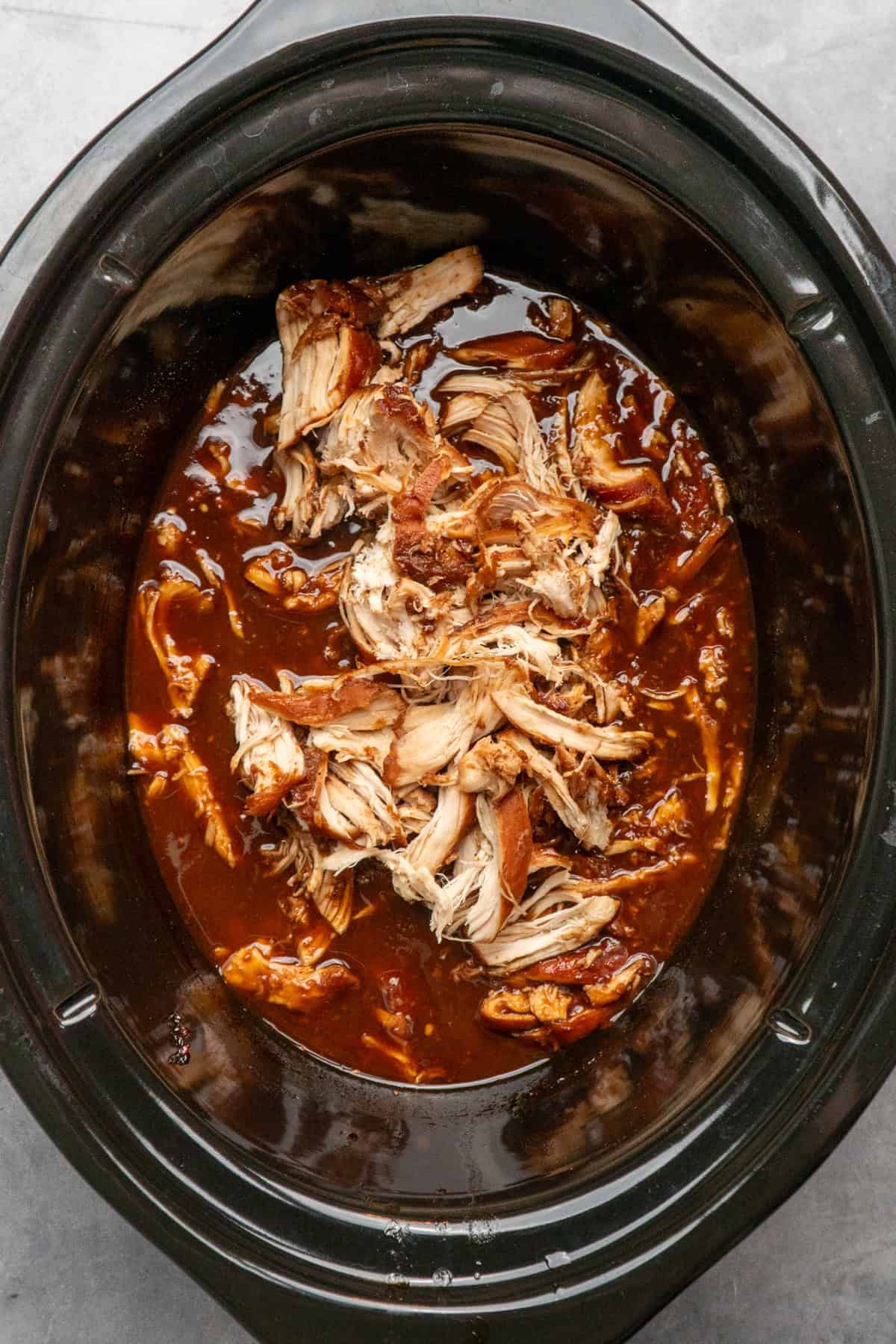 Chicken in the crock pot with sauce after shredding.