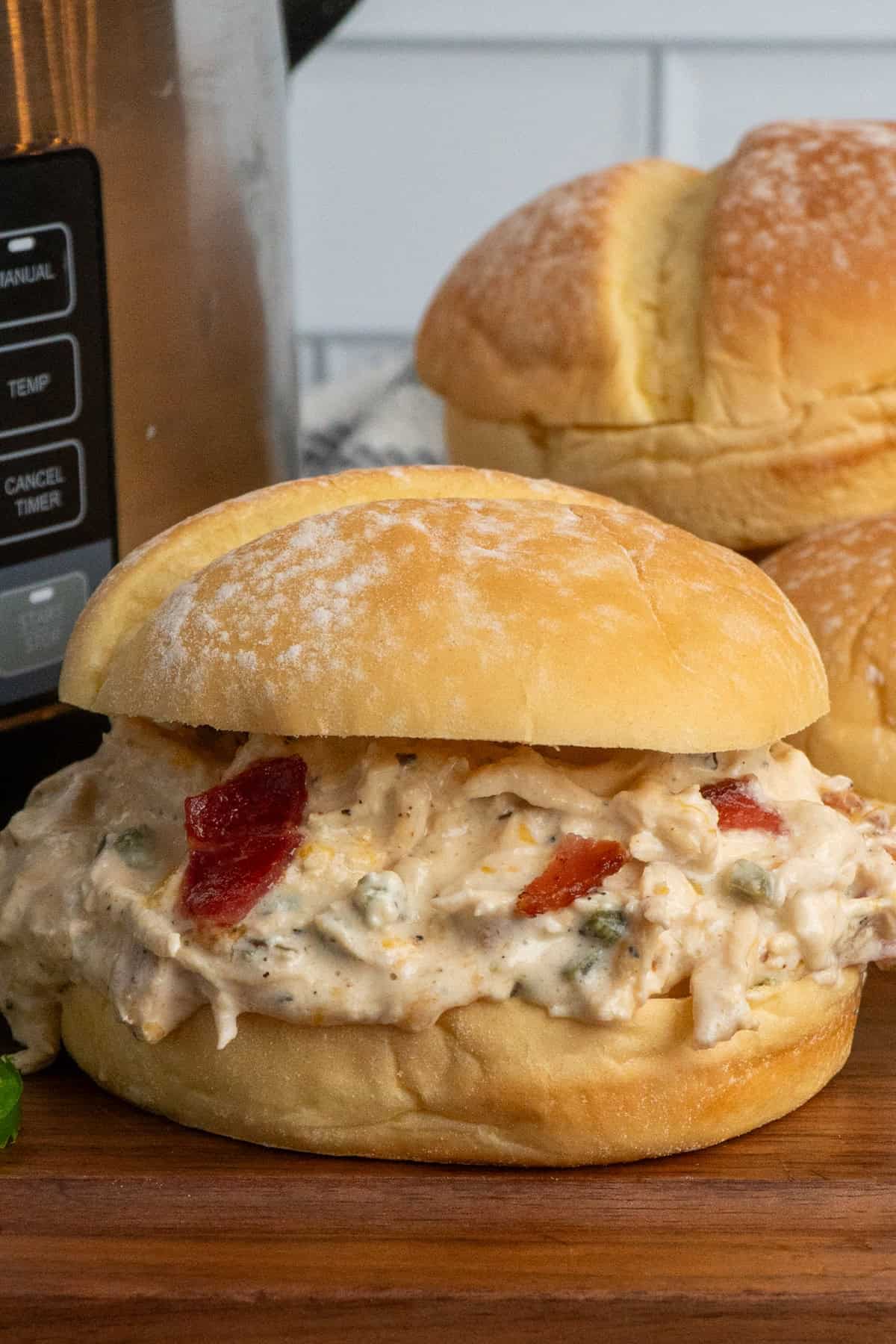 Crock pot jalapeno popper chicken on a potato bun.