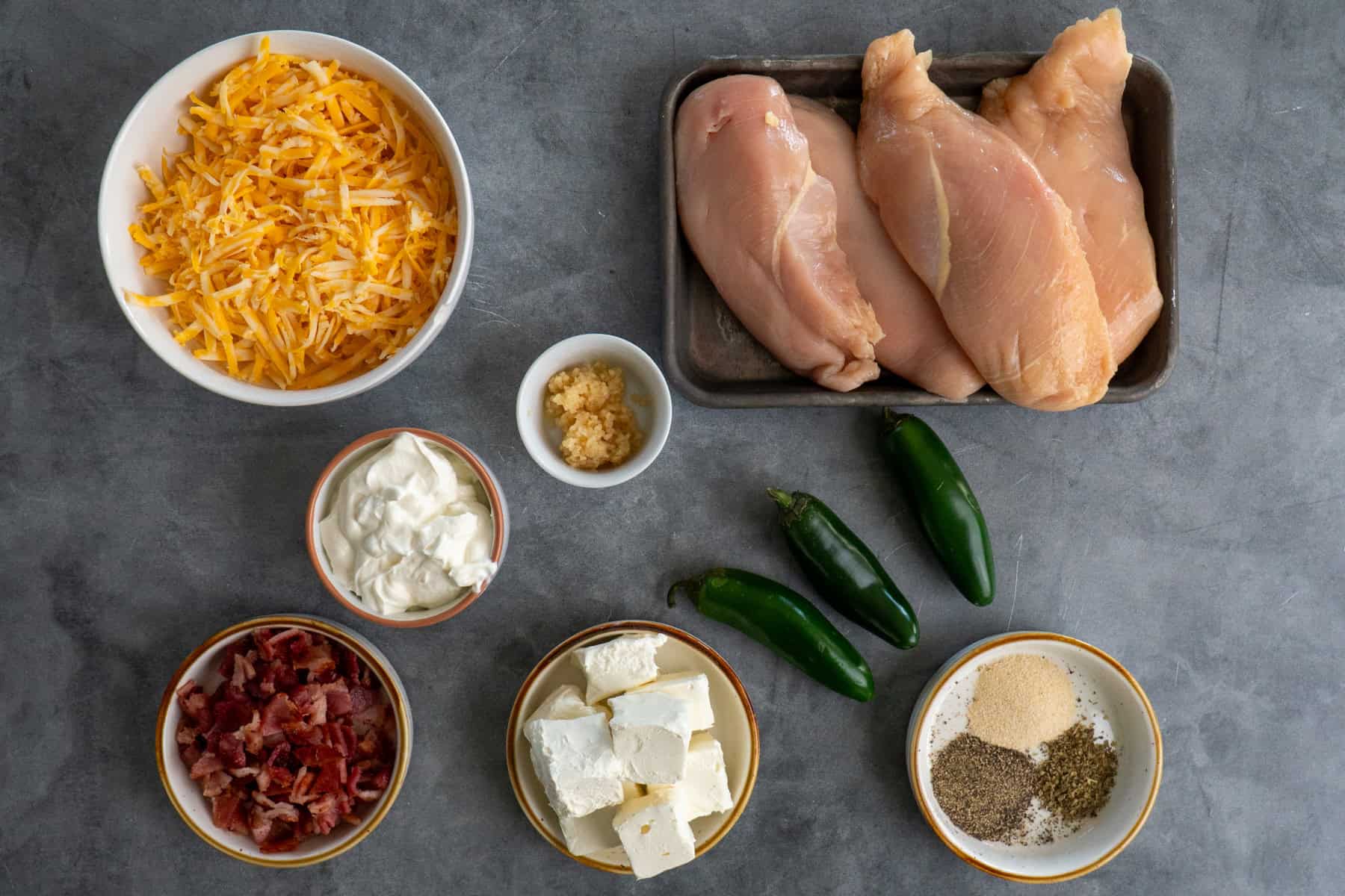 Ingredients for jalapeno popper chicken in bowls on a countertop.