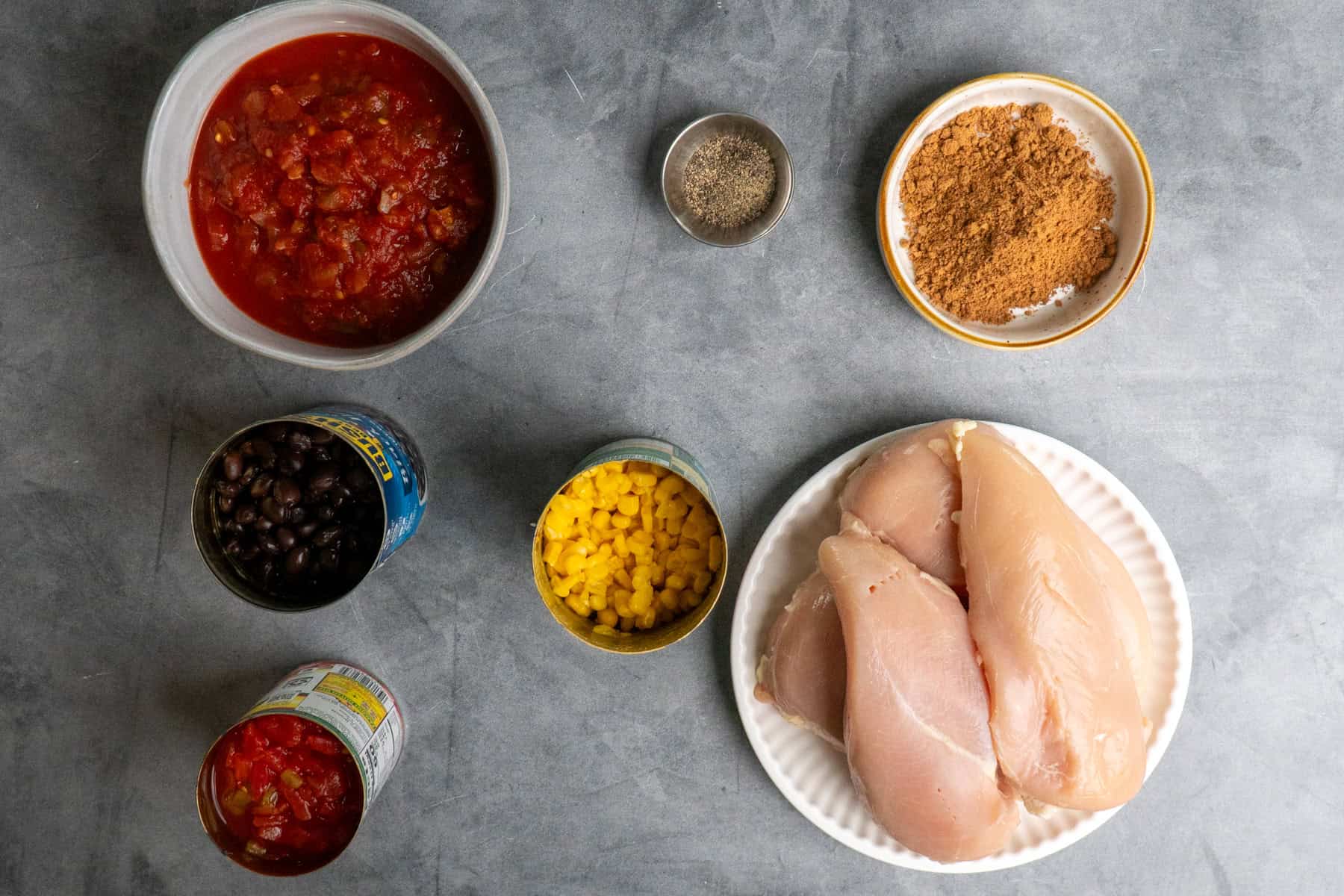 Ingredients to make crock pot southwest chicken on a gray countertop.