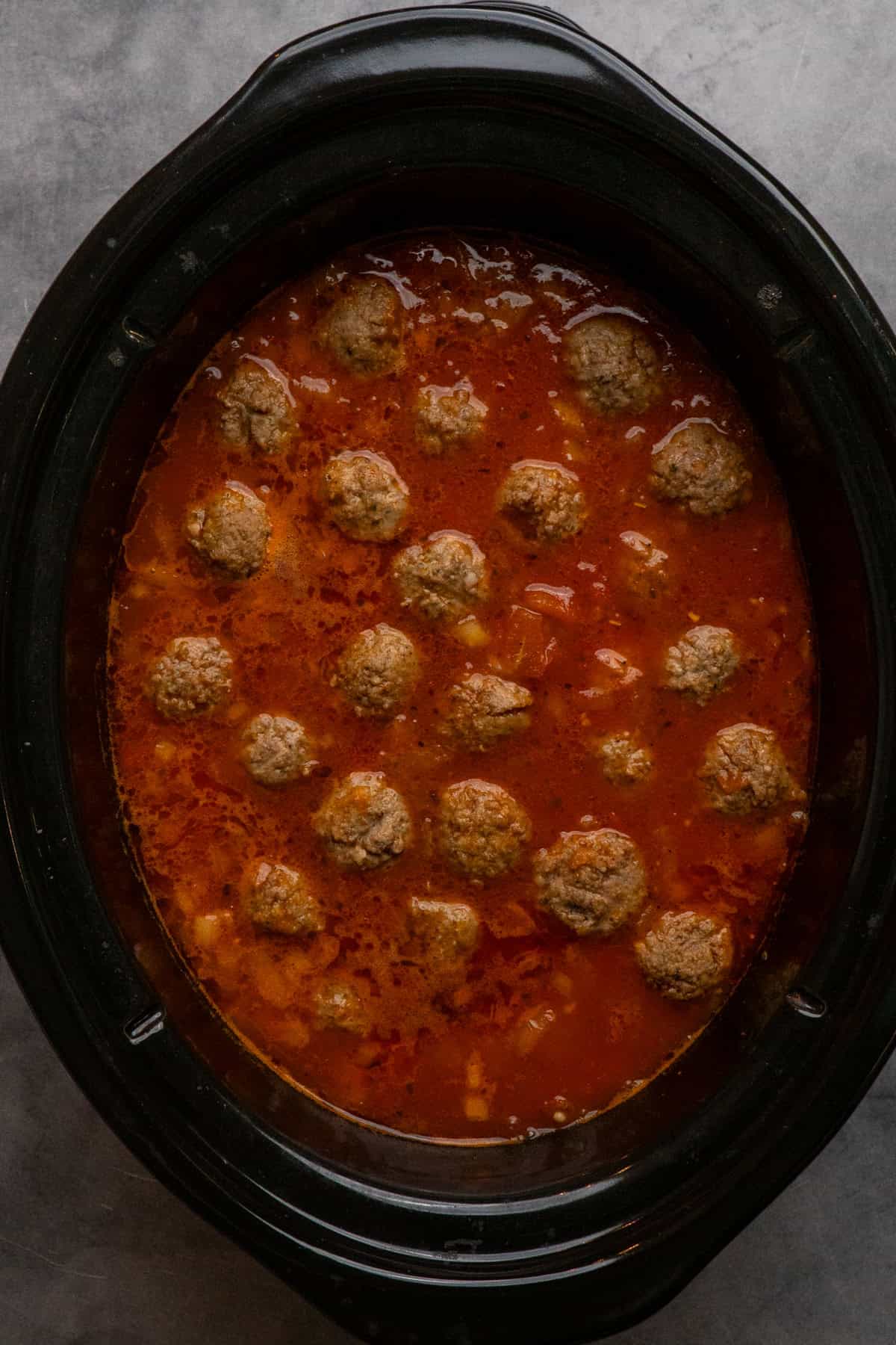 Meatballs and broth after they have been cooked.