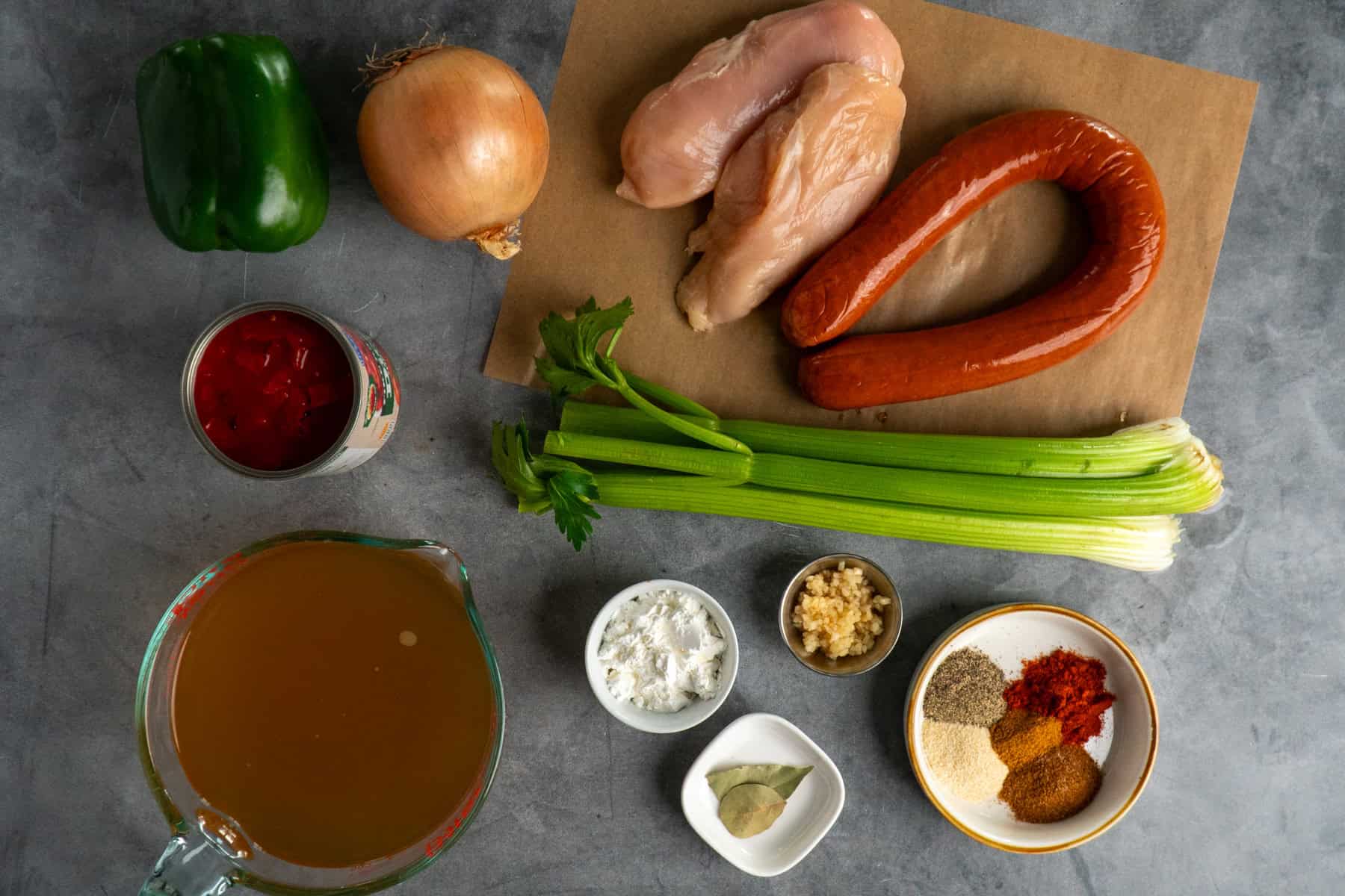 Ingredients to make chicken and sausage gumbo on a countertop.