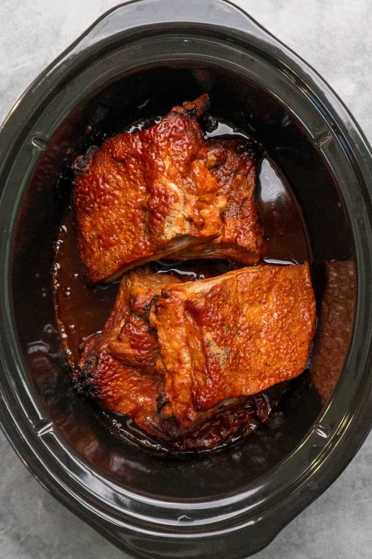 Cooked baby back ribs in the slow cooker.