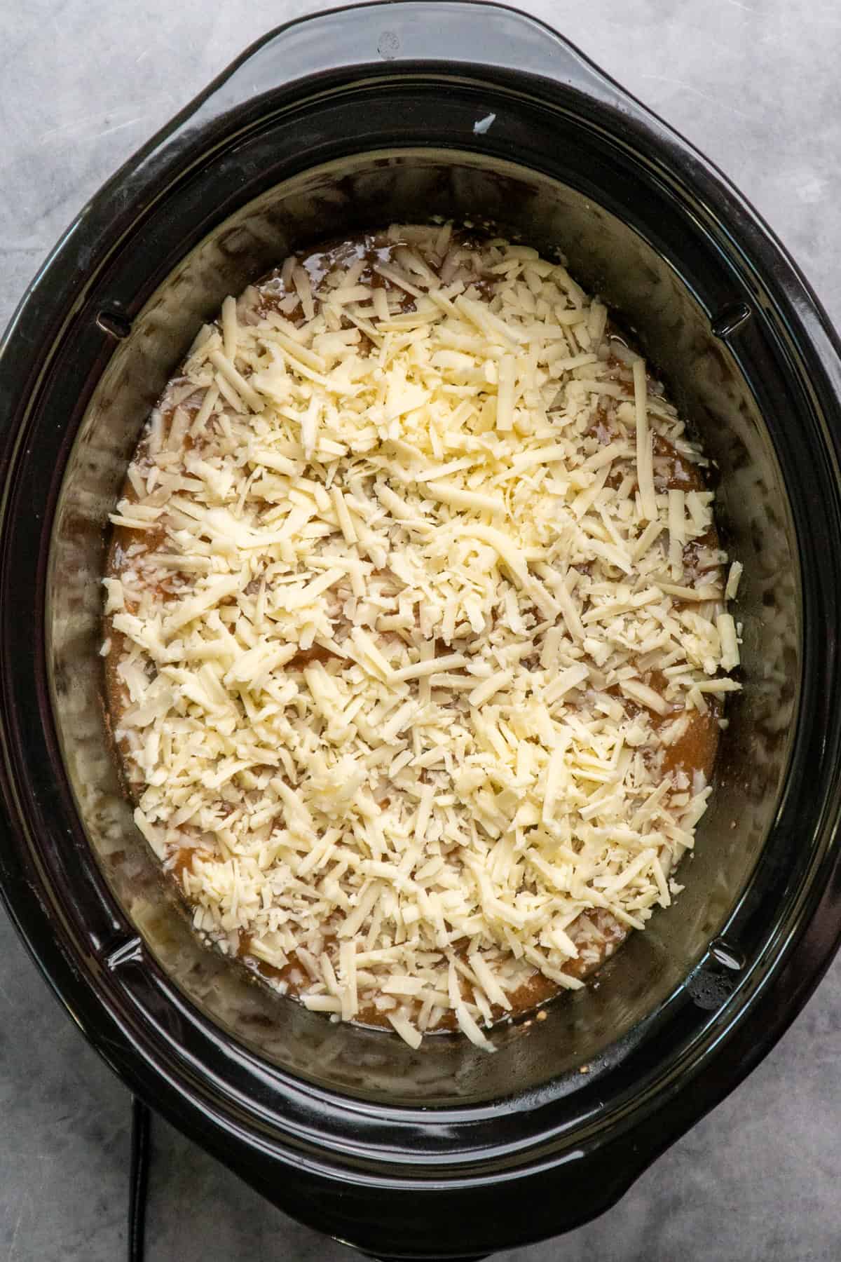 Cheese on top of pork chops in a crock pot.