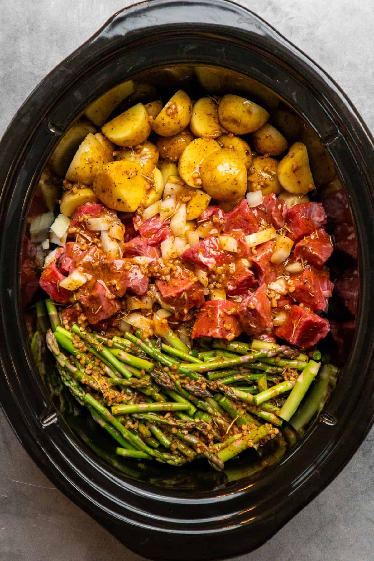 Garlic butter sauce poured over meat, potatoes and asparagus.