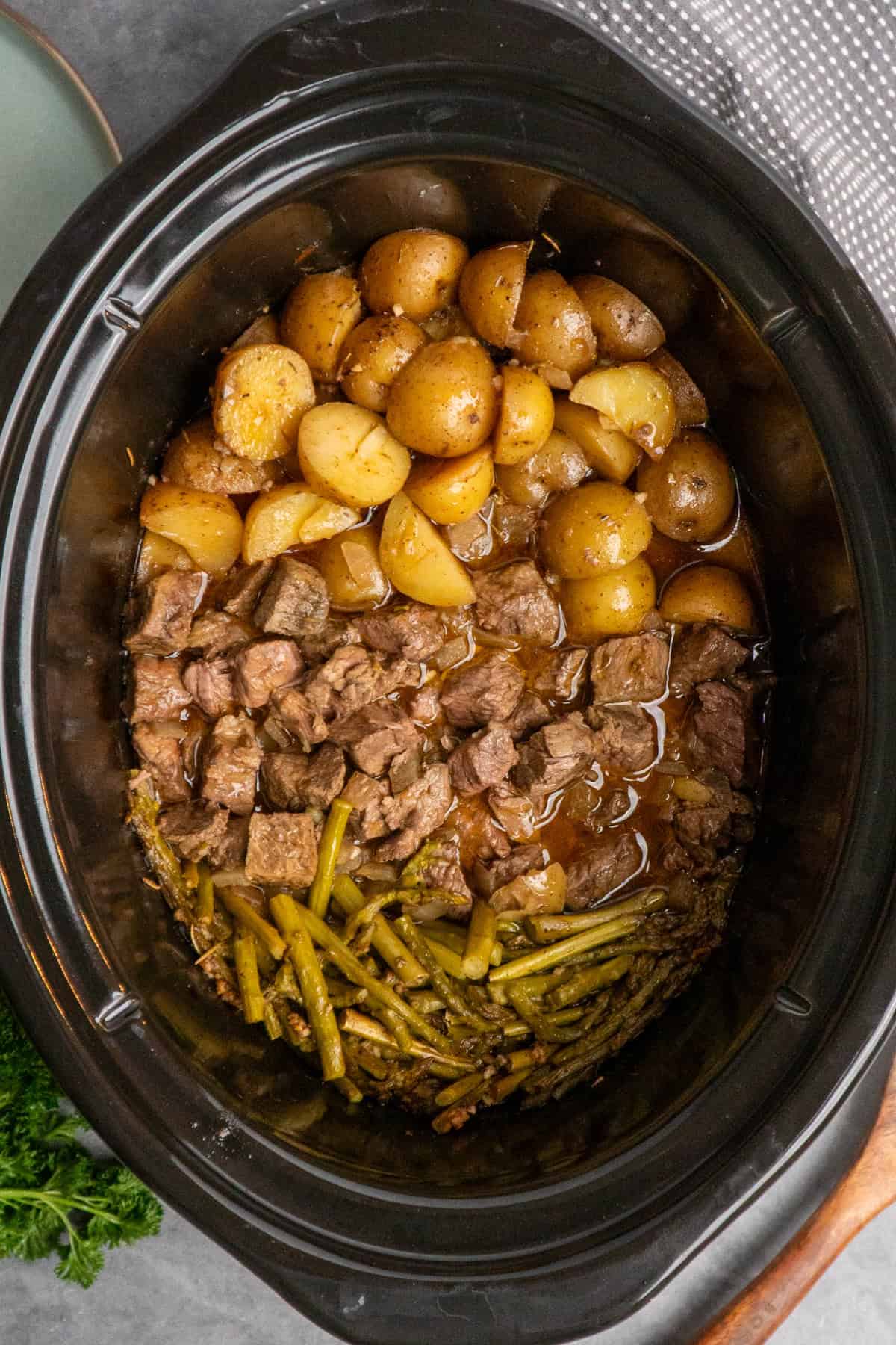 Cooked garlic butter steak bites in a crock pot ready to be served.