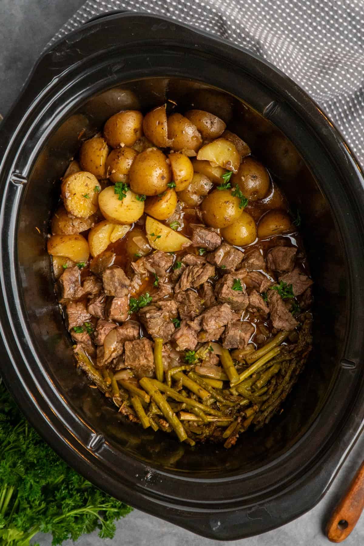 Cooked garlic butter steak bites in a crock pot ready to be served.