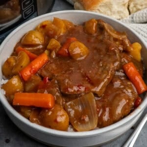 A bowl of crockpot swiss steak on the table ready to eat.