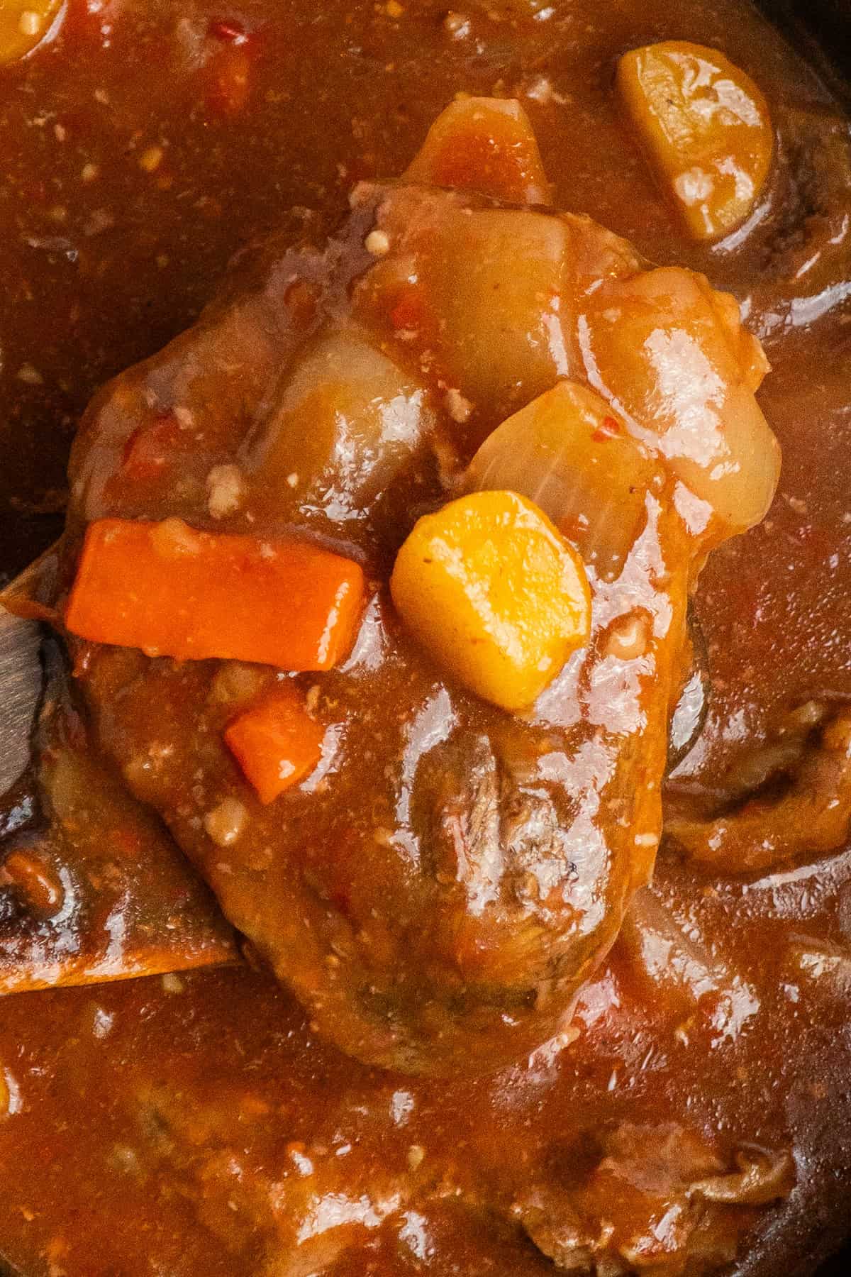 Swiss steak with potatoes and carrots in a sauce.