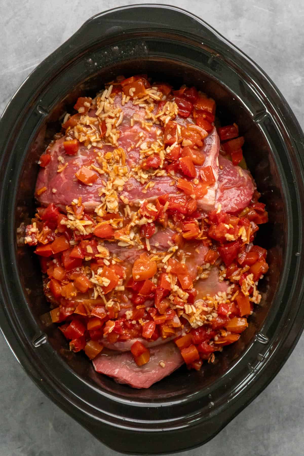 Sauce poured over the steaks in a slow cooker.