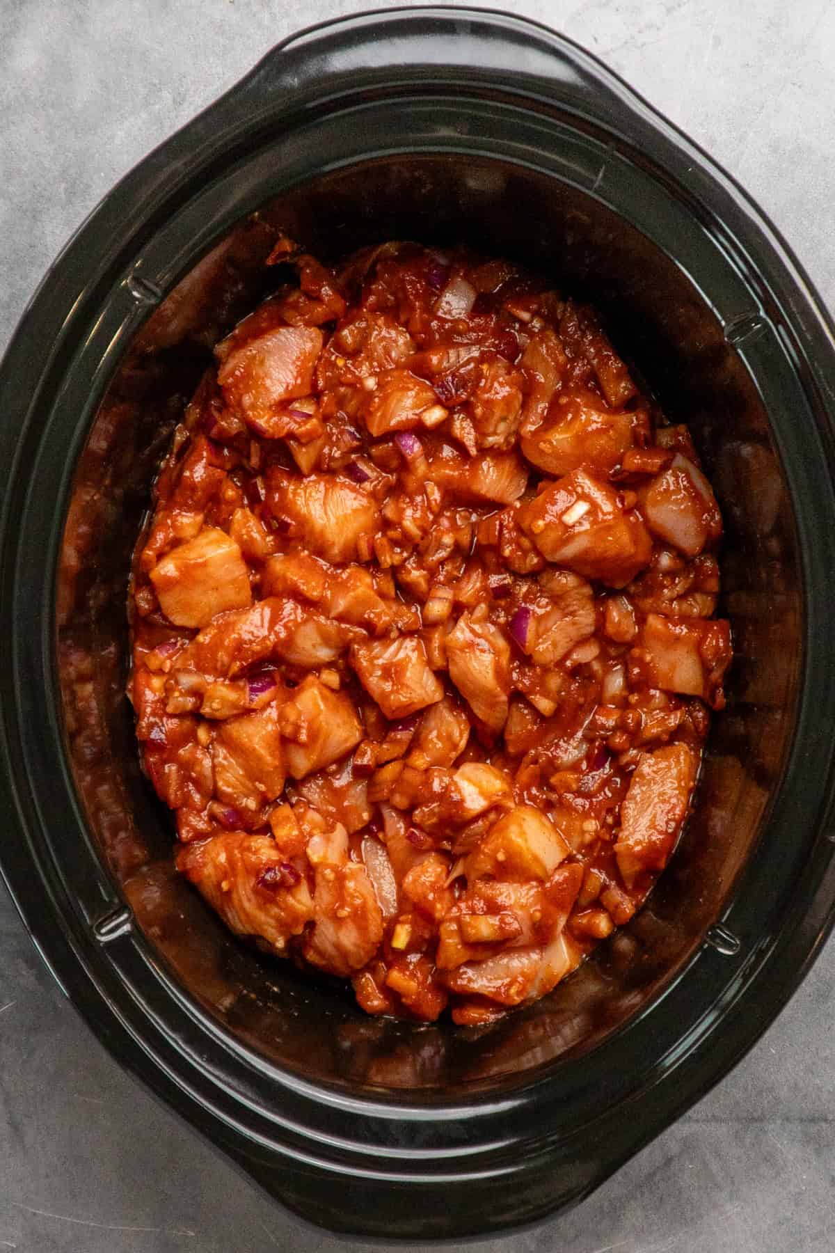 Tikka masala ingredients mixed together in a crock pot ready to cook.