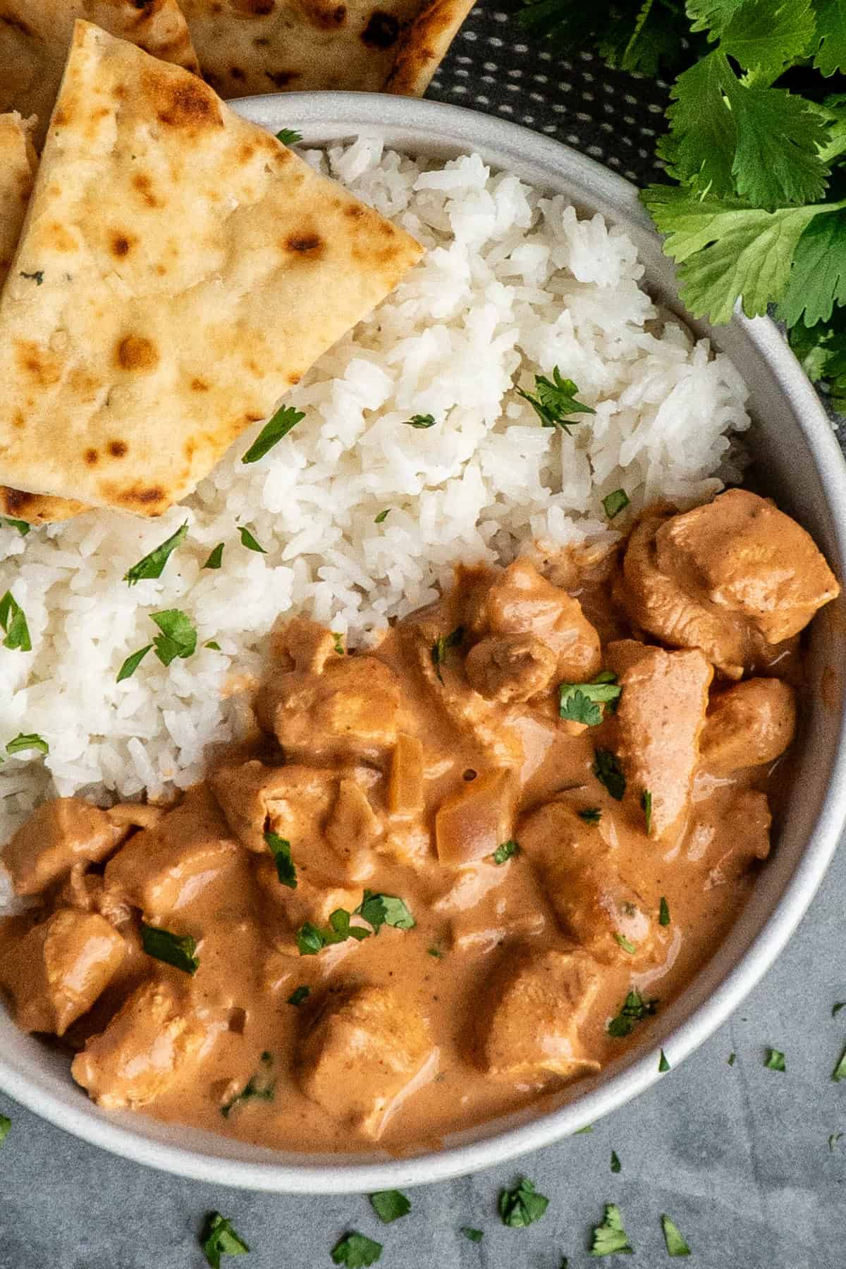 Crock Pot tikka masala in a bowl with rice and naan bread.